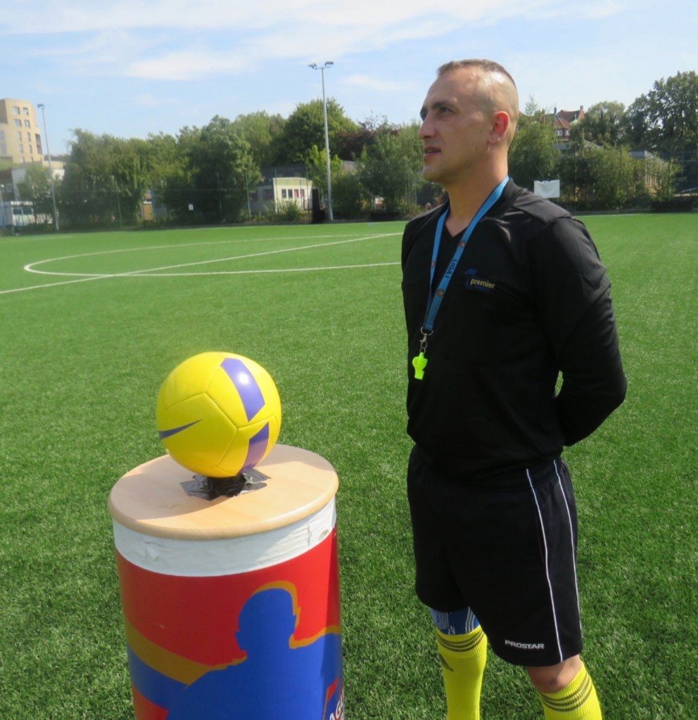 A match official beside the match ball before kick-off