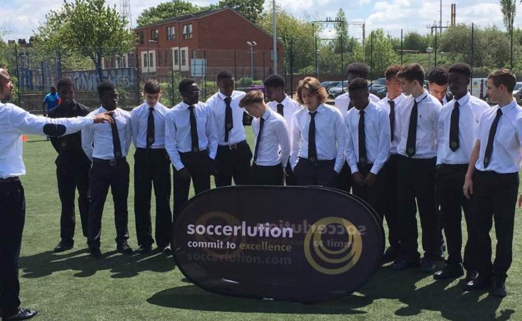 A squad in shirts and ties receiving a team talk